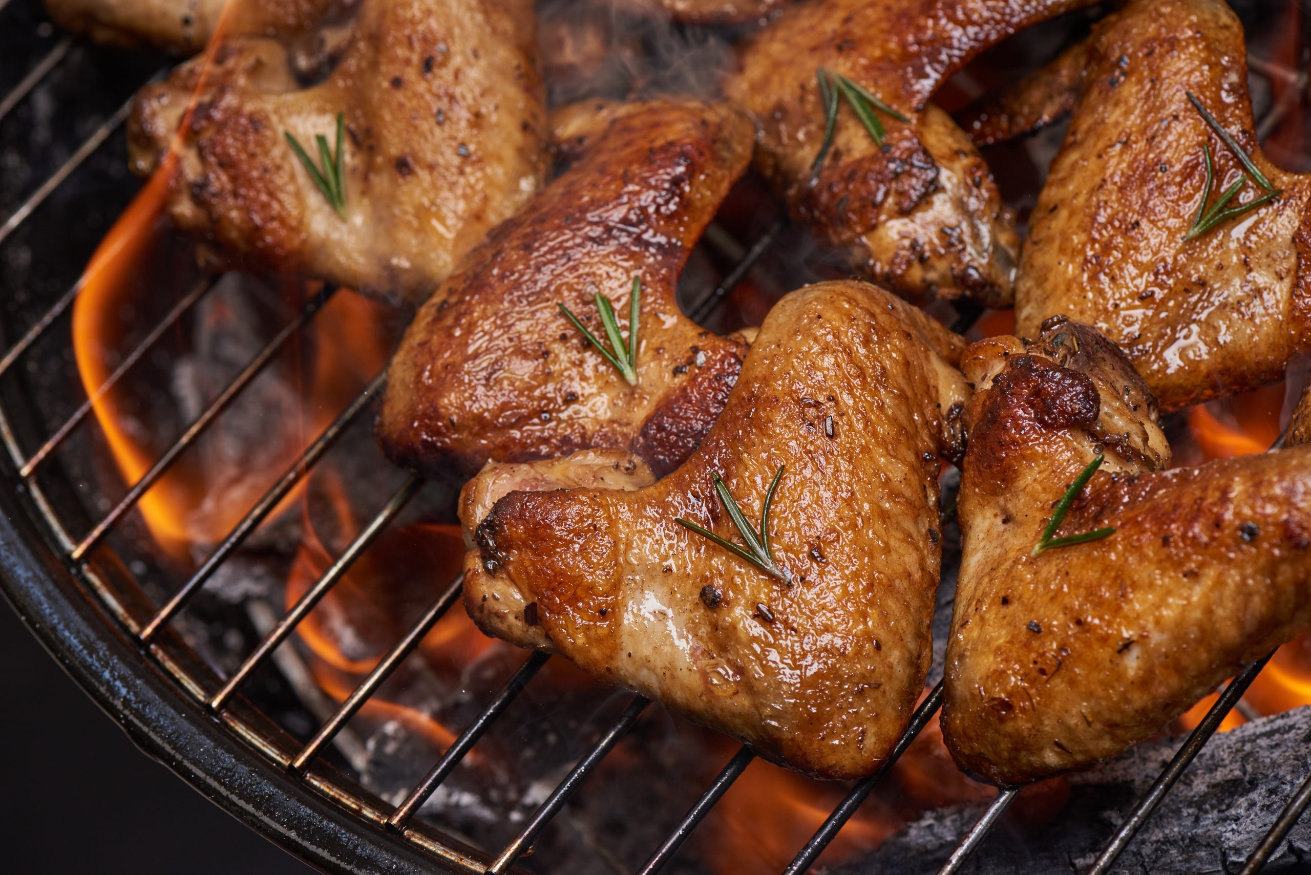 Juicy chicken wings on a flaming grill