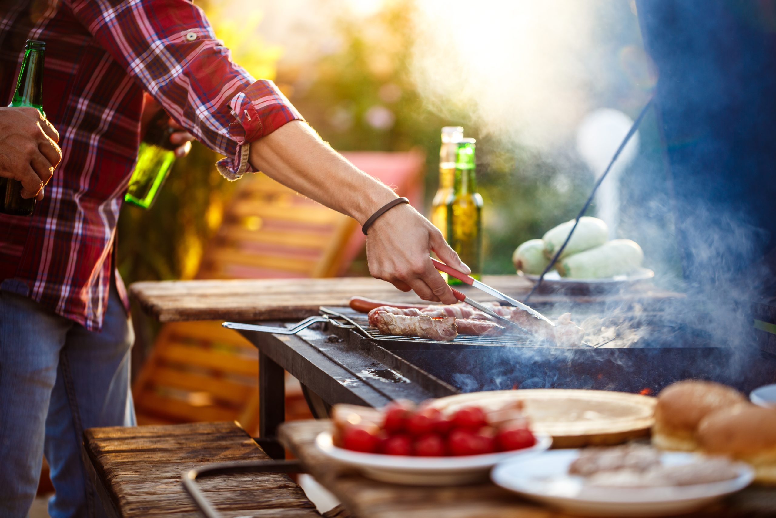 Friends braaiing around a grill